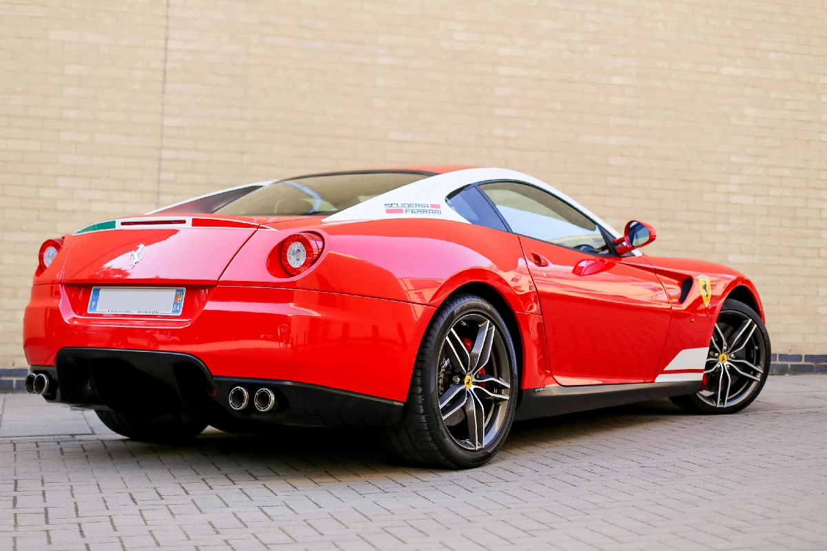 A red sports car parked on the side of a building.